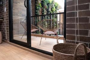 a patio with two chairs and a basket on a balcony at Casa Rosé Hotel in Carmen de Viboral