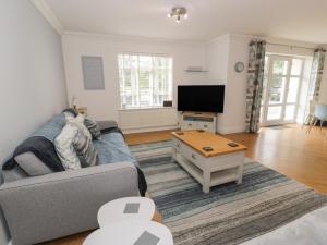 a living room with a couch and a tv at Apartment 6 in Morfa Nefyn