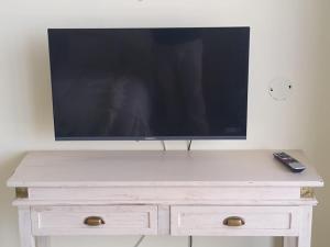 a television on top of a white dresser with a remote control at Departamento Paseo de los Poetas Premium in Salta