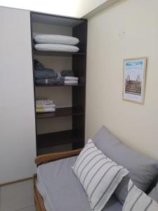 a bedroom with a bed and a shelf with towels at Departamento Paseo de los Poetas Premium in Salta
