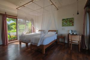 a bedroom with two beds and a large window at Lesong Hotel and Restaurant in Munduk +91 photos