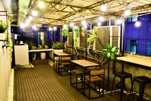 a bar with tables and stools in a room with plants at Inn Cube - Taipei Main Station in Taipei