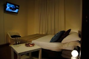 ローマにあるPapia Guest Houseのベッドルーム1室(ベッド1台、テーブル、テレビ付)