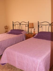 2 camas en una habitación con sábanas moradas en Casa Los Olivos, en Grávalos