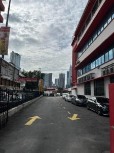 una calle de la ciudad con coches aparcados en un estacionamiento en Akar Hotel Jalan TAR, en Kuala Lumpur