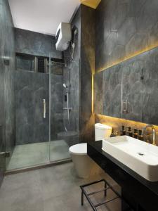 y baño con lavabo, ducha y aseo. en JSI Resort en Puncak