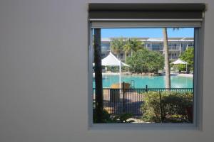 uma vista para uma piscina a partir de uma janela em Peppers Salt Resort & Spa - Lagoon pool access 2 br spa suite em Kingscliff