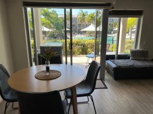 a living room with a table and chairs and a patio at Peppers Salt Resort & Spa - Lagoon pool access 2 br spa suite in Kingscliff