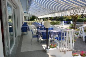 a patio with blue tables and chairs on a building at Hotel Paris in Lignano Sabbiadoro