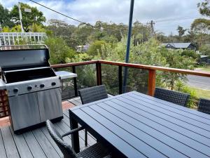 Pambula BeachにあるSails to Sea - 4 Bedroom Pet Friendly Private Poolのデッキのグリルとピクニックテーブル