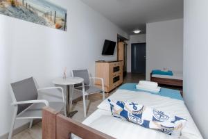 une chambre avec un lit, une table et des chaises dans l'établissement Apartament YAGI z bezpłatnym parkingiem Dziwnówek nad morzem EPapartamenty, à Dziwnówek