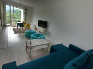 a living room with a blue couch and a table at Panoramic Residence in Zărneşti