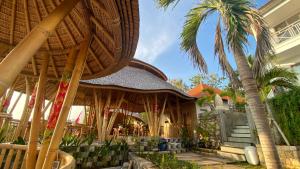 a building with a palm tree in front of it at The Kama in Nusa Penida