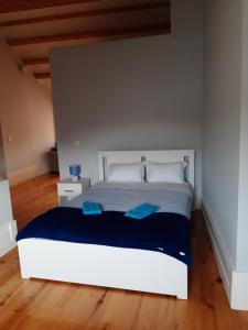 1 dormitorio con 1 cama blanca con sábanas azules en São Bartolomeu Apartment 4, en Coímbra