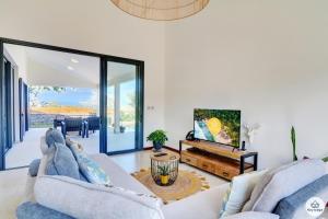 ein Wohnzimmer mit einem Sofa und einem Tisch in der Unterkunft Villa Aïna - Piscine 4 étoiles - Vue mer - Saint Leu in Saint-Leu