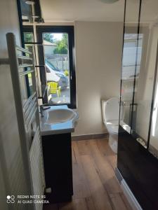 PleurtuitにあるJENNY'S HOMEのバスルーム(洗面台、トイレ付)、窓が備わります。
