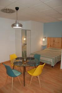 a room with a table and chairs and a bed at Amplio estudio en centro y playa Victoria 13 in Málaga