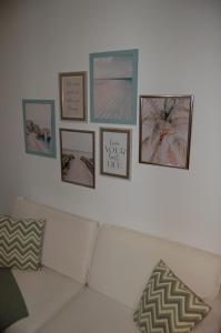 a living room with a white couch and pictures on the wall at Amplio estudio en centro y playa Victoria 13 in Málaga