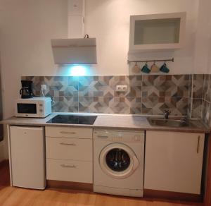 a kitchen with a washing machine and a sink at Amplio estudio en centro y playa Victoria 13 in Málaga