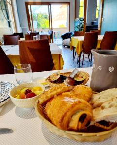 een tafel met een bord brood en fruitschalen bij Le Terminus in LʼArbresle