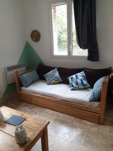 ein Sofa im Wohnzimmer mit Fenster in der Unterkunft Le mas gnolia in Saint-Jean-du-Gard