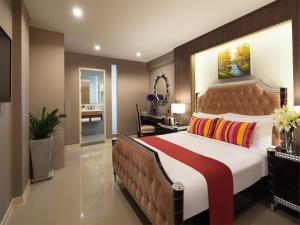 a bedroom with a large bed with a brown headboard at Ton Aor Place Hotel in Bangkok