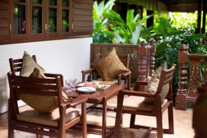 a wooden table and chairs with a meal on a patio at Smile House - Fisherman Village in Bophut
