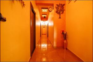 a hallway with yellow walls and a door and a vase of flowers at FabHotel Vijaylakshmi Stay Inn in Chennai