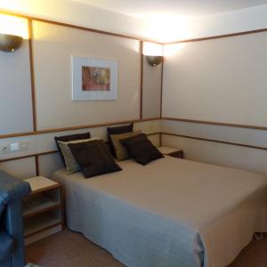 バゼイユにあるChâteau de Bazeillesのベッドルーム(大型ベッド1台、青い椅子付)