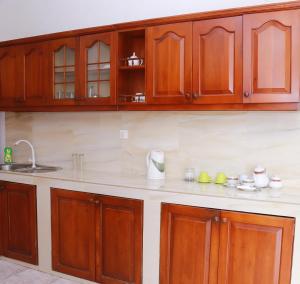 a kitchen with wooden cabinets and a counter top at Hillstreet Villa in Dehiwala +18 photos