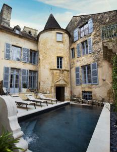 a building with a swimming pool in front of it at LE PETIT MANOIR in Sarlat-la-Canéda