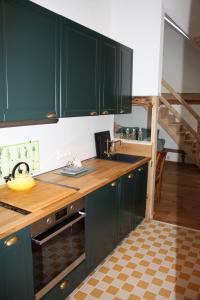 a kitchen with green cabinets and a wooden counter top at Wohnung Alter Heuboden im Fachwerk bei Bonn Alfter in Heidgen