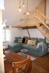 a living room with a blue couch and a loft at Wohnung Alter Heuboden im Fachwerk bei Bonn Alfter in Heidgen