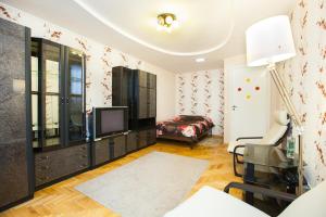 ein Wohnzimmer mit einem TV und einem Stuhl in der Unterkunft Standard Brusnika Apartment Kantemirovskaia in Moskau
