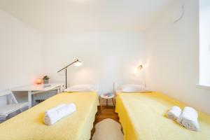 deux lits dans une chambre avec des draps jaunes dans l'établissement APARTMENT 396, à Ljubljana