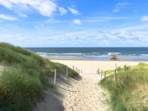 a sandy path leading to a beach with the ocean at Appealing Holiday Home in De Koog Texel with Sauna in Westermient