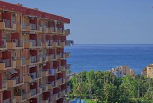 wysoki budynek z widokiem na ocean w obiekcie Parque de la Paloma Area - Benalmadena Costa w mieście Benalmádena