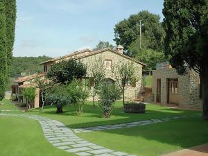 a house with a green yard with a stone pathway at Air conditioned flat with pool and wellness area in Ravigliano