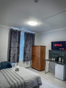 um quarto de hotel com uma cama e uma televisão em The New George Hotel em Newcastle upon Tyne