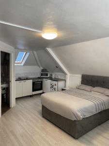 a bedroom with a large bed and a kitchen at The New George Hotel in Newcastle upon Tyne