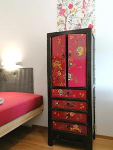 un tocador con dibujos rojos junto a una cama en Ferienhaus Peggy, en Kurort Oybin