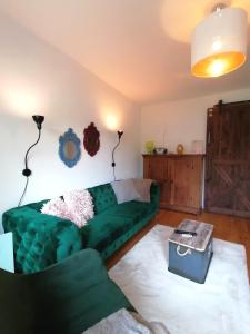 a living room with a green couch and a table at Ferienhaus Peggy in Kurort Oybin