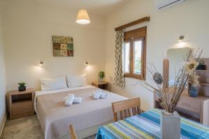 1 dormitorio con 2 camas, mesa y ventana en Frank Apartments, en Amoudara Herakliou