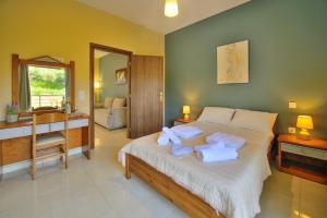 a bedroom with a bed with towels on it at Naiades Summer House I in Plátanos