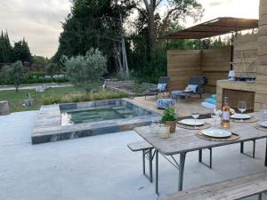 een patio met een tafel en een zwembad bij Mas Aupiho in Saint-Rémy-de-Provence