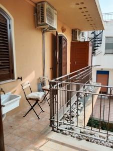 d'un balcon avec un escalier et une chaise. dans l'établissement Il faro di Ganzirri, à Messina