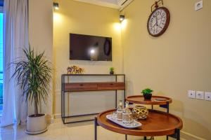 a living room with two tables and a clock on the wall at Naiades Summer House I in Plátanos