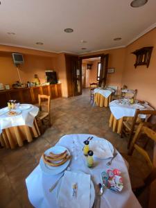 a dining room with two tables with white table cloth at Hotel Hostería de Monzón in Monzón de Campos