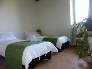 - une chambre avec 2 lits avec des draps verts et blancs dans l'établissement Holiday home Cielsereno, à Radicondoli