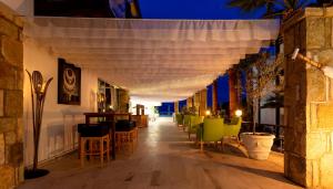 a bar with chairs and tables on a patio at night at CHARM BEACH HOTEL in Akyarlar